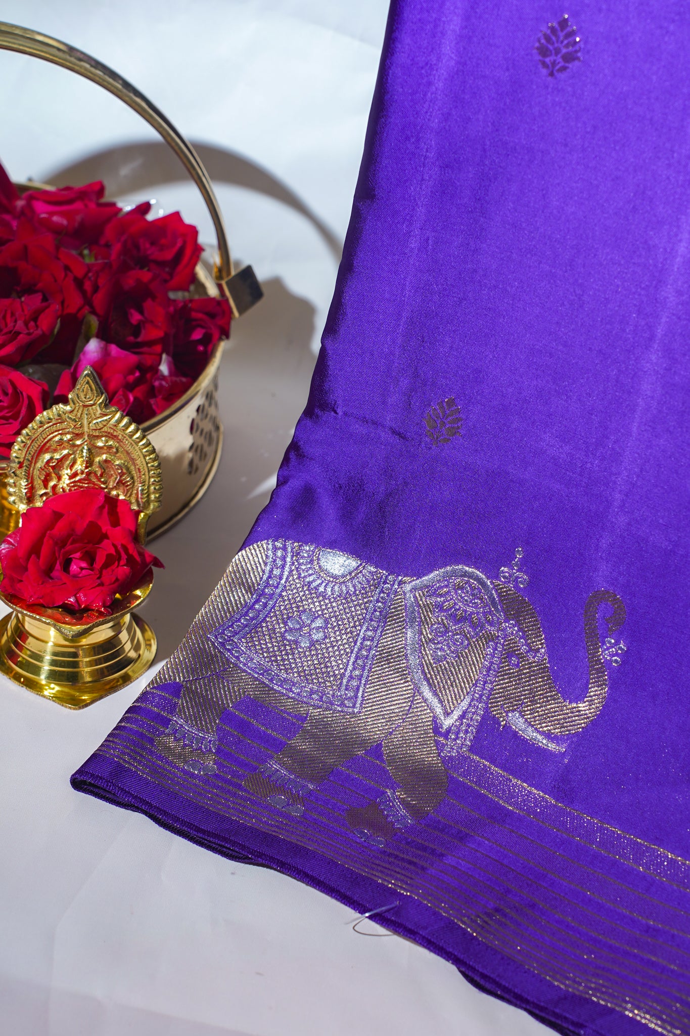 Purple fabric with silver elephant design on a white background
