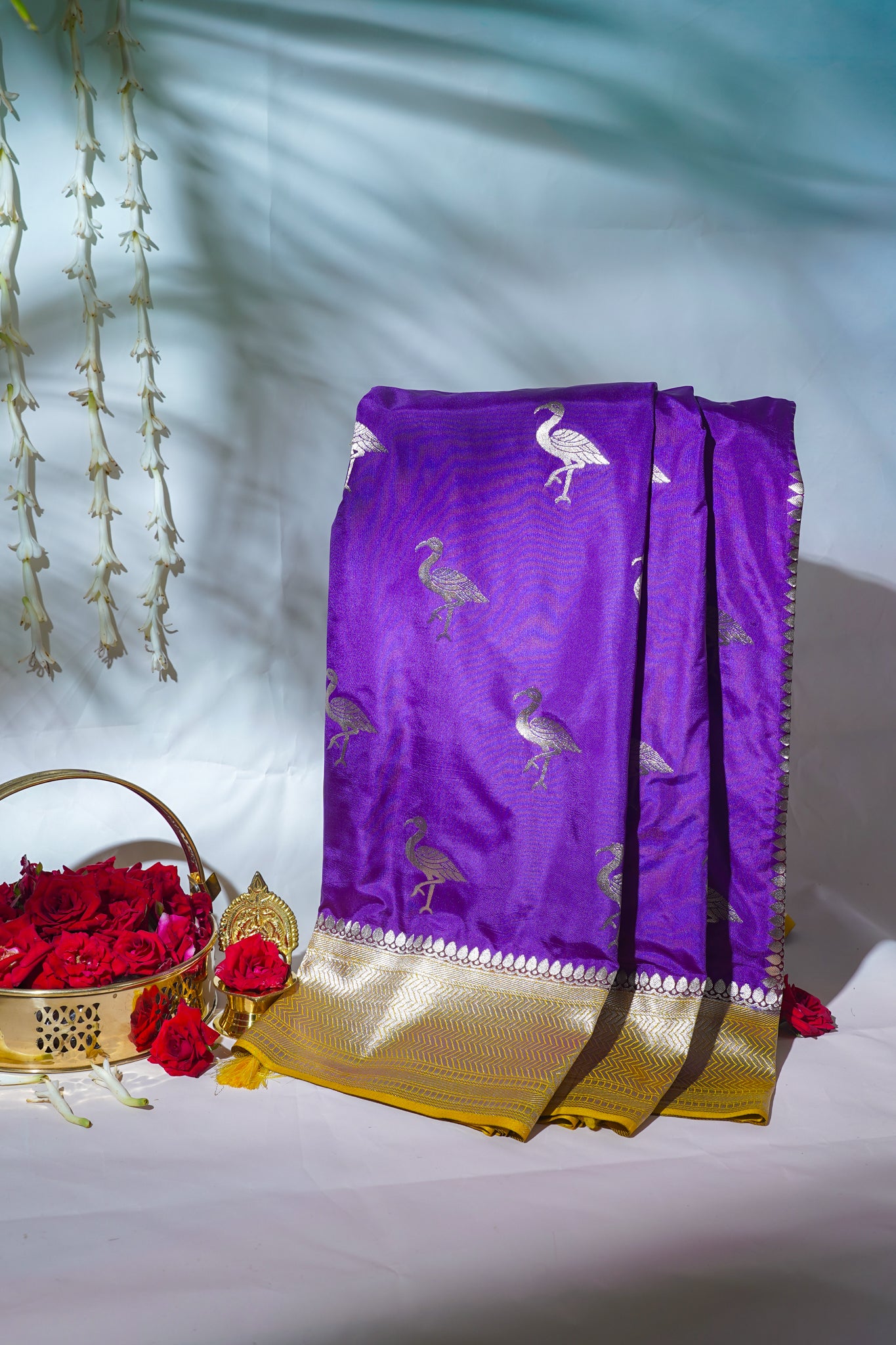 Purple saree with bird patterns on a white background