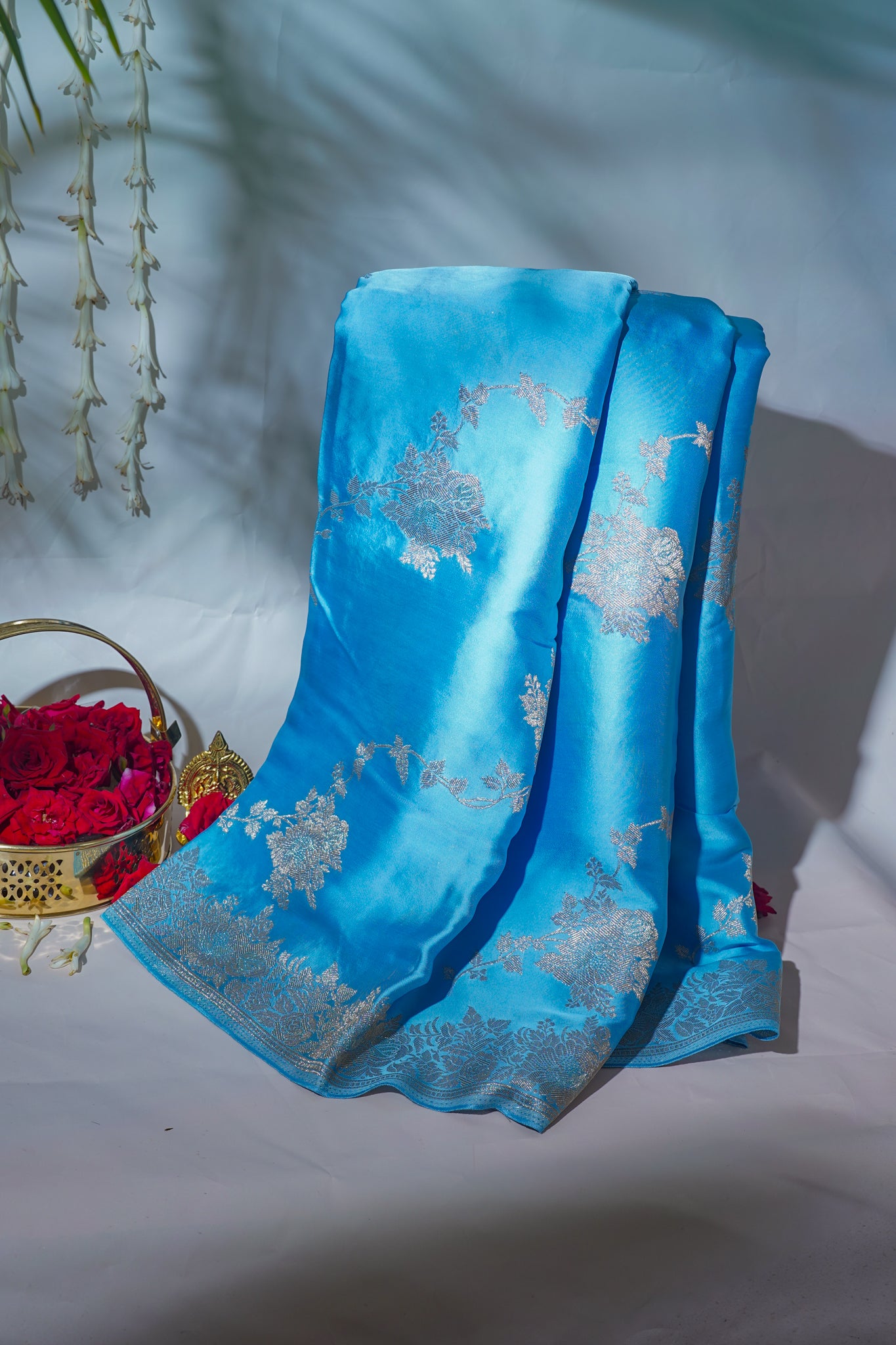 Blue saree with silver patterns on a white surface