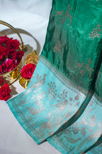 Green saree with silver floral patterns on a white background