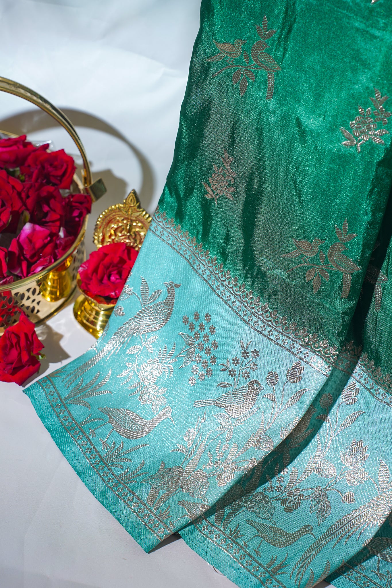 Green saree with silver floral patterns on a white background
