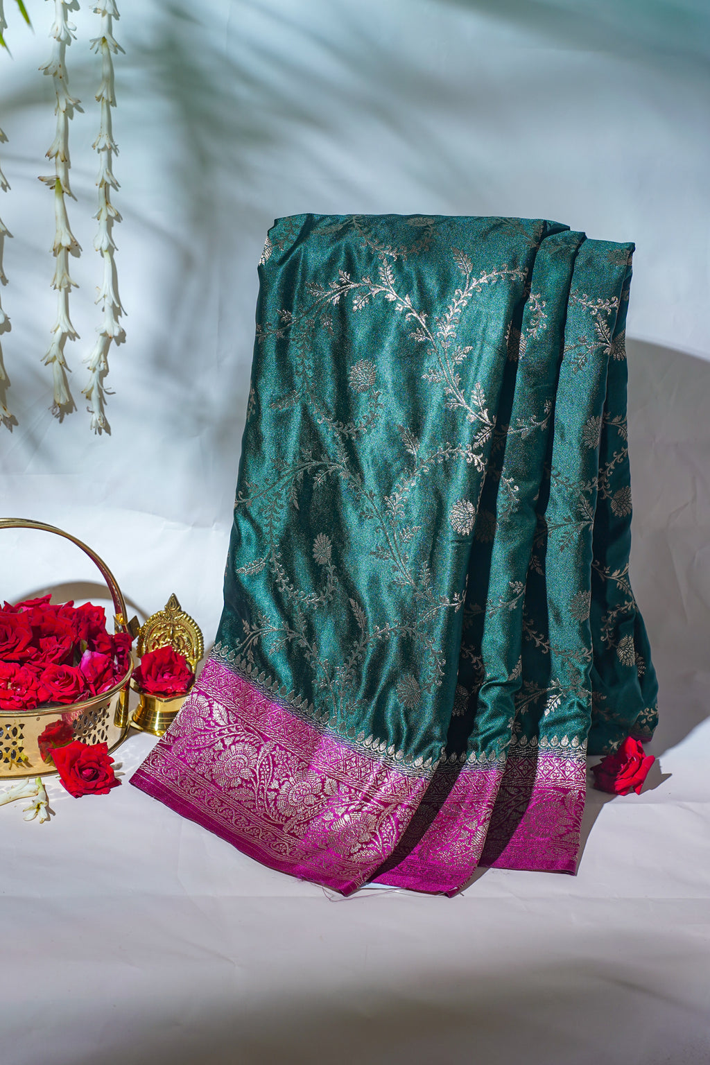 Green saree with pink border on a white background