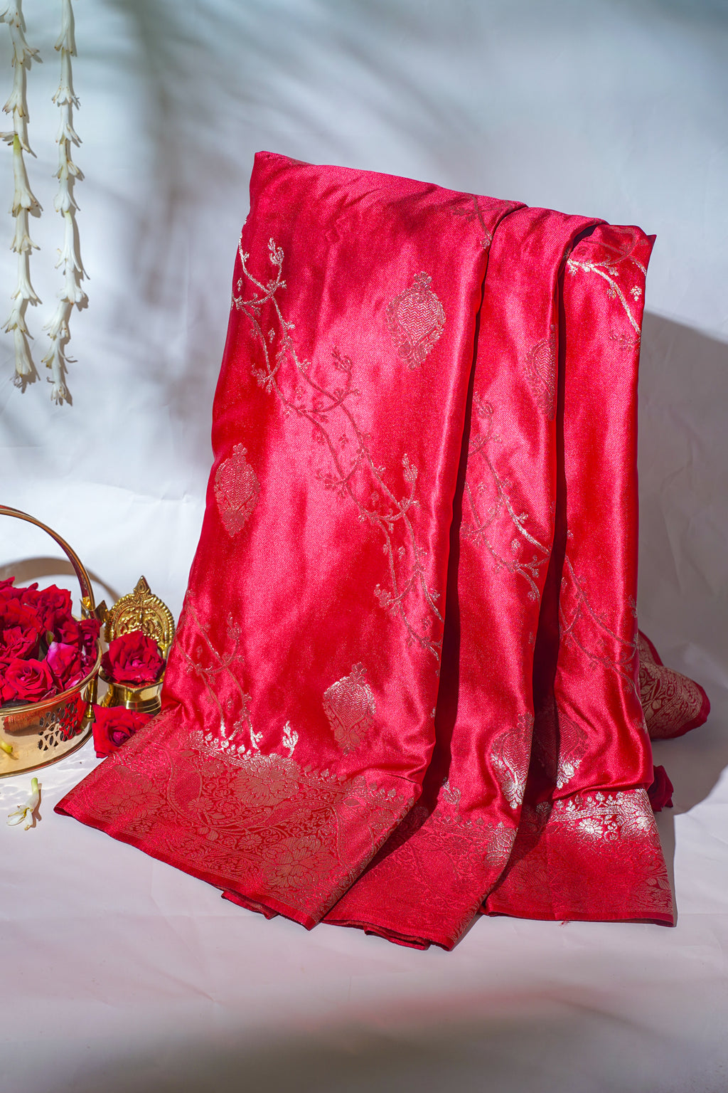 Red embroidered fabric with floral patterns on a white background