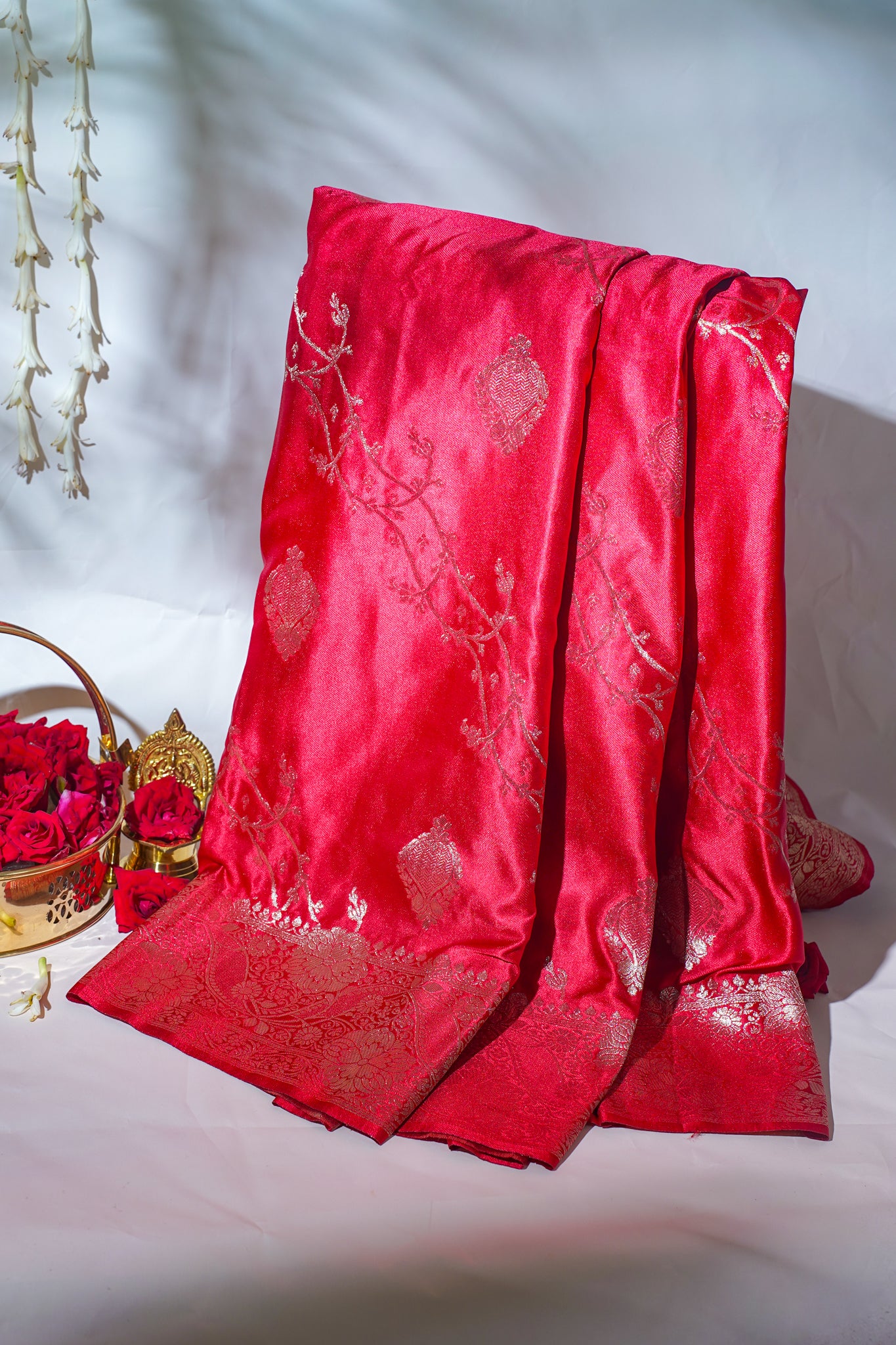 Red embroidered fabric with floral patterns on a white background