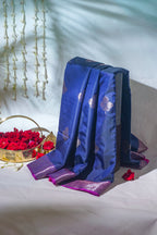Blue fabric with purple accents on a white surface with red flowers and a decorative basket.