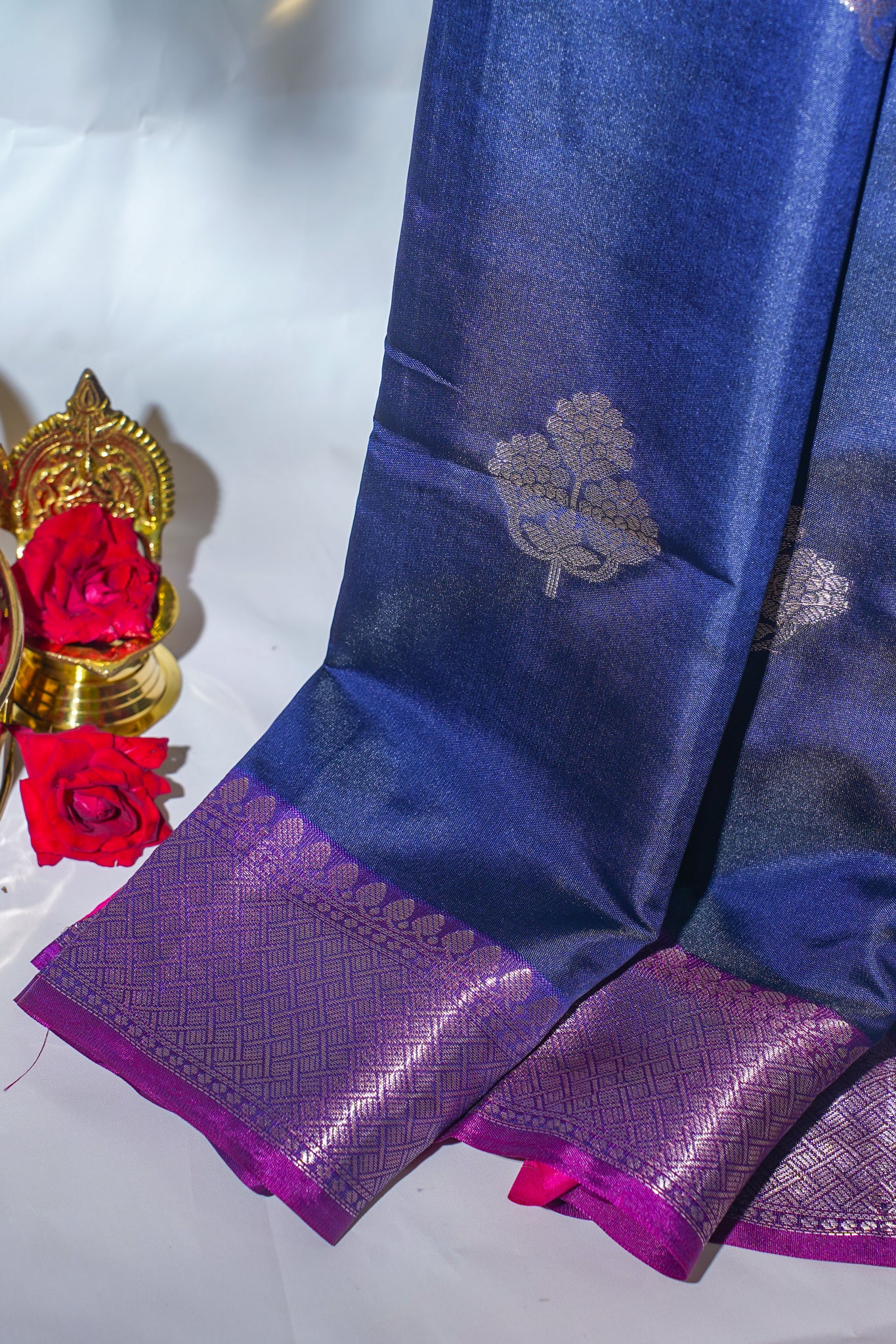 Blue and purple saree with floral patterns on a white background