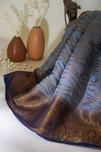 Blue and brown patterned Saree with decorative elements on a white surface