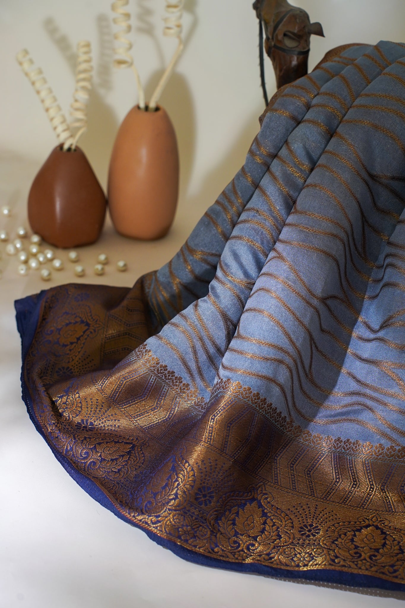 Blue and brown patterned Saree with decorative elements on a white surface