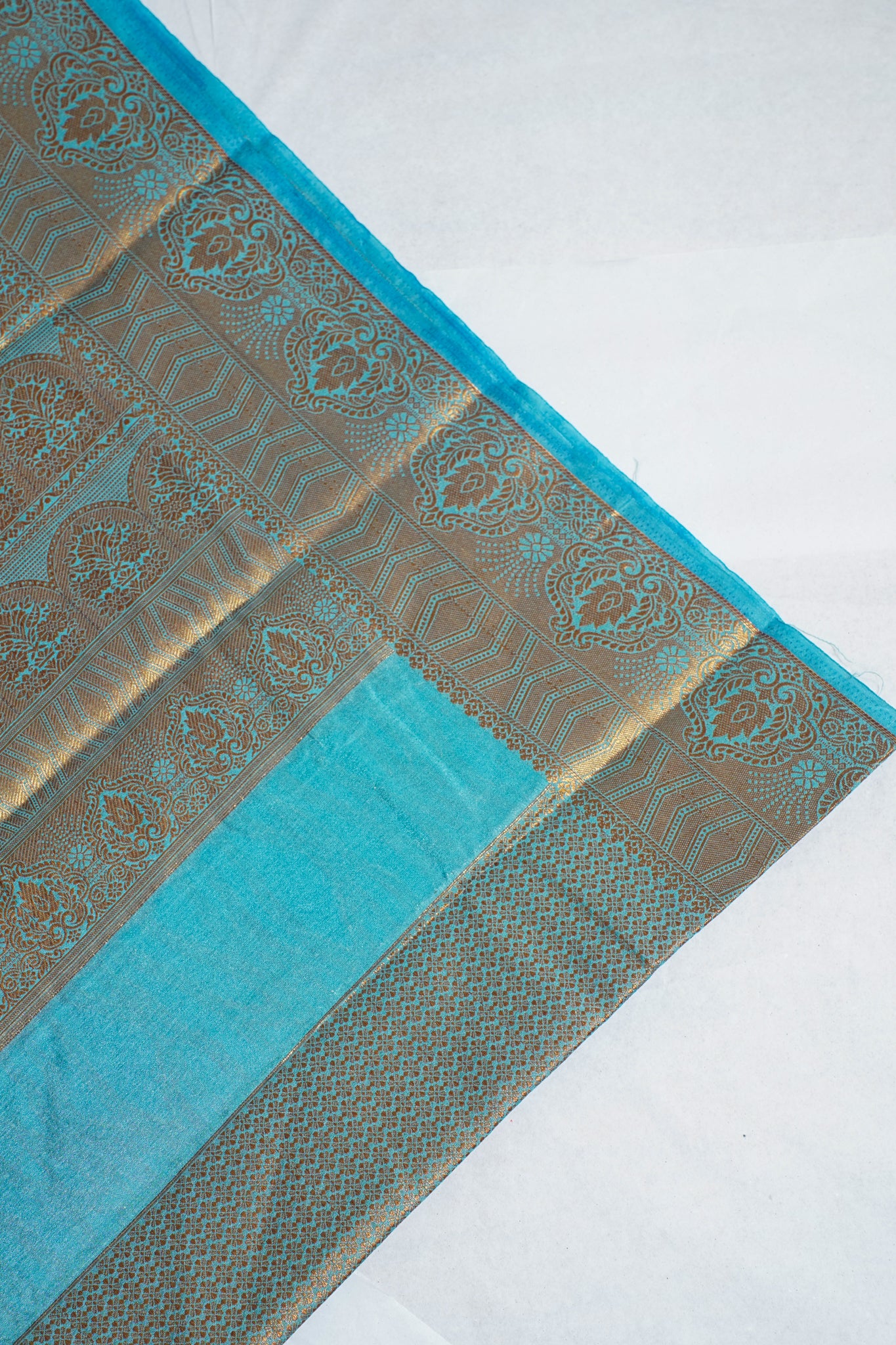 Decorative fabric with blue and gold patterns on a white background