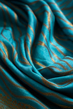Close-up of teal fabric with gold stripes