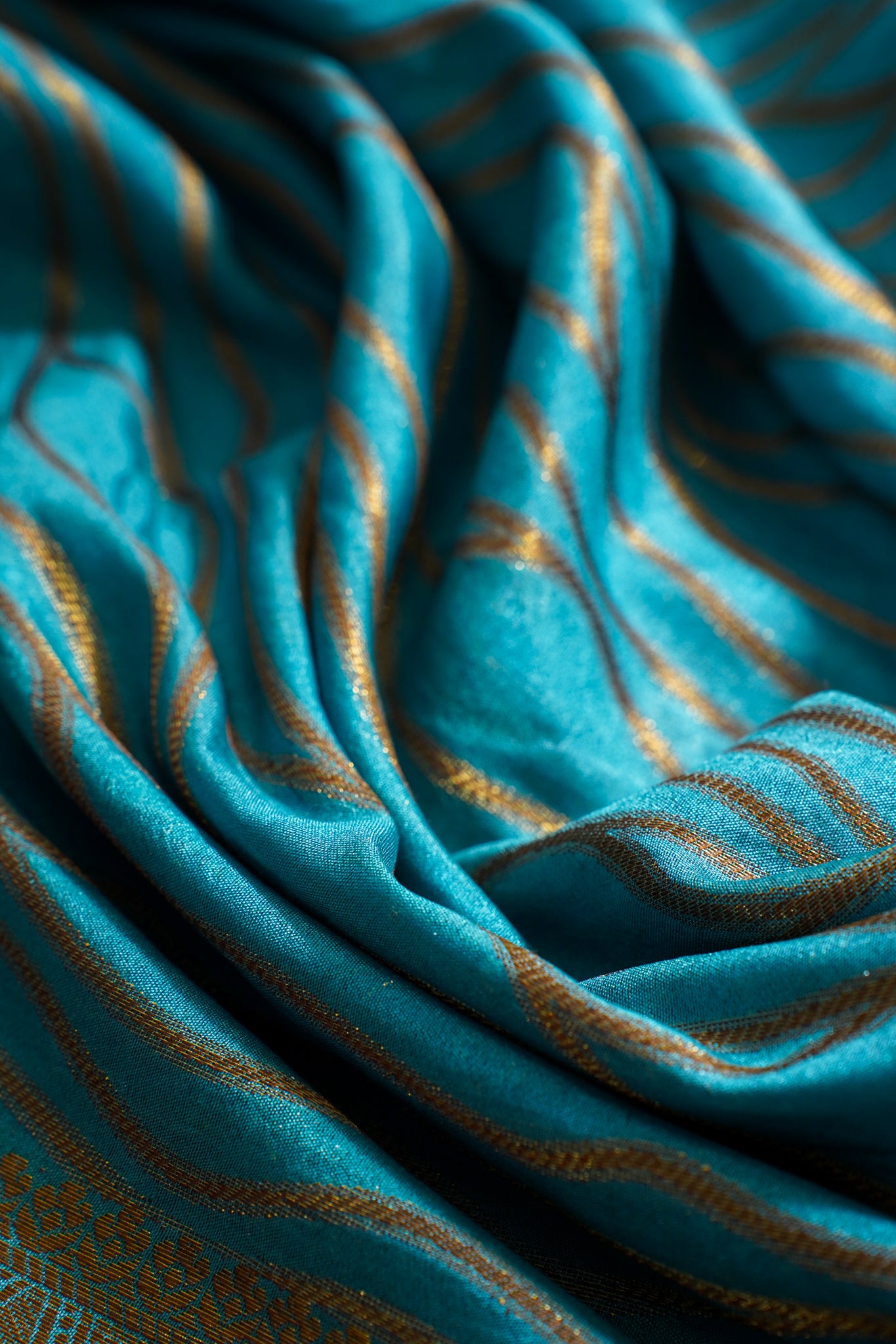Close-up of teal fabric with gold stripes