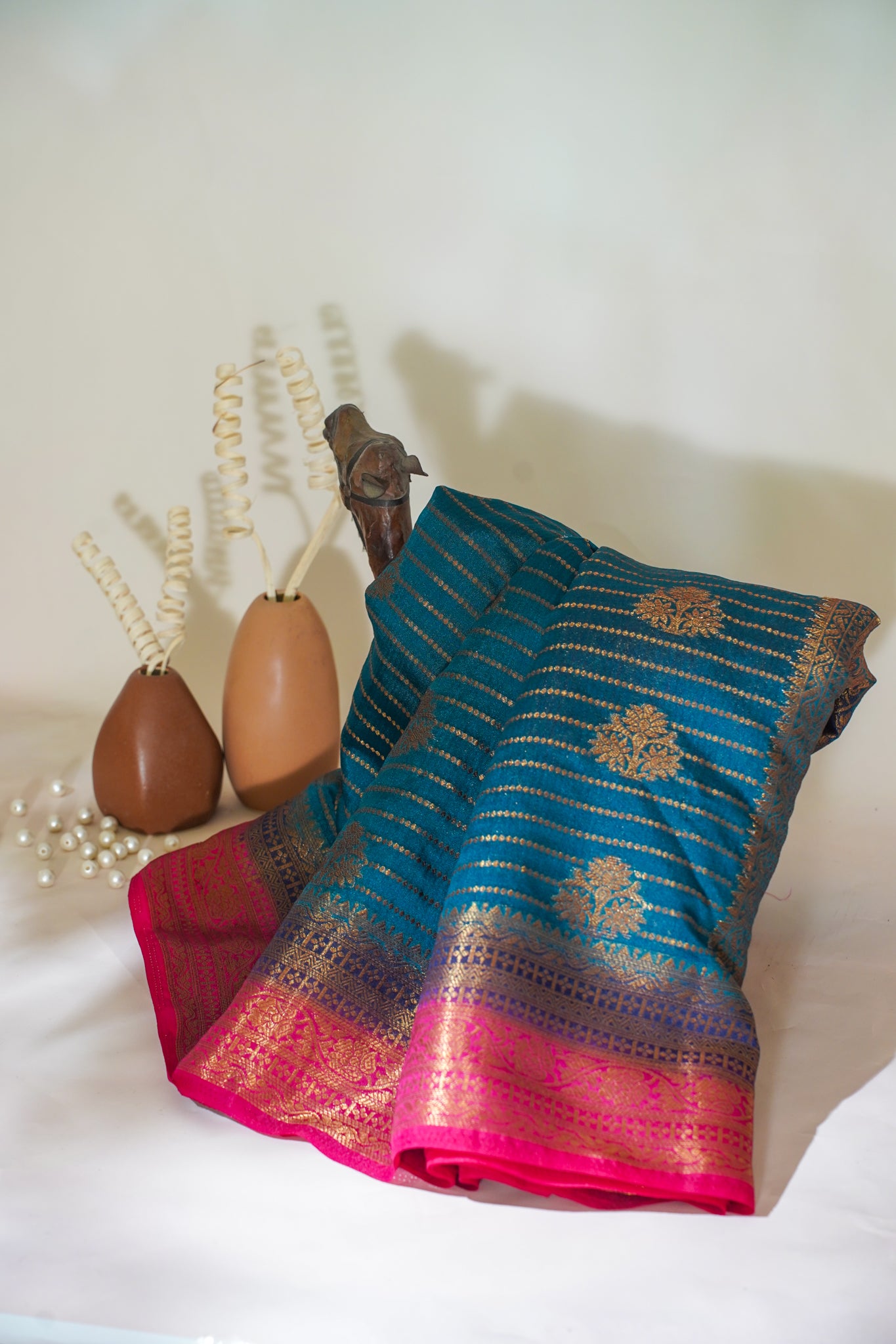 Blue and pink saree with decorative elements on a white surface
