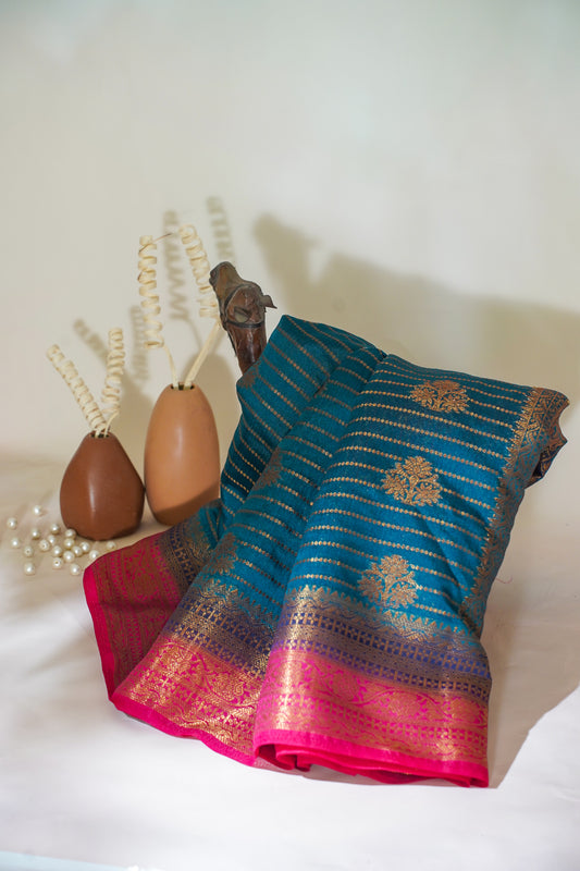 Blue and pink saree with decorative elements on a white surface