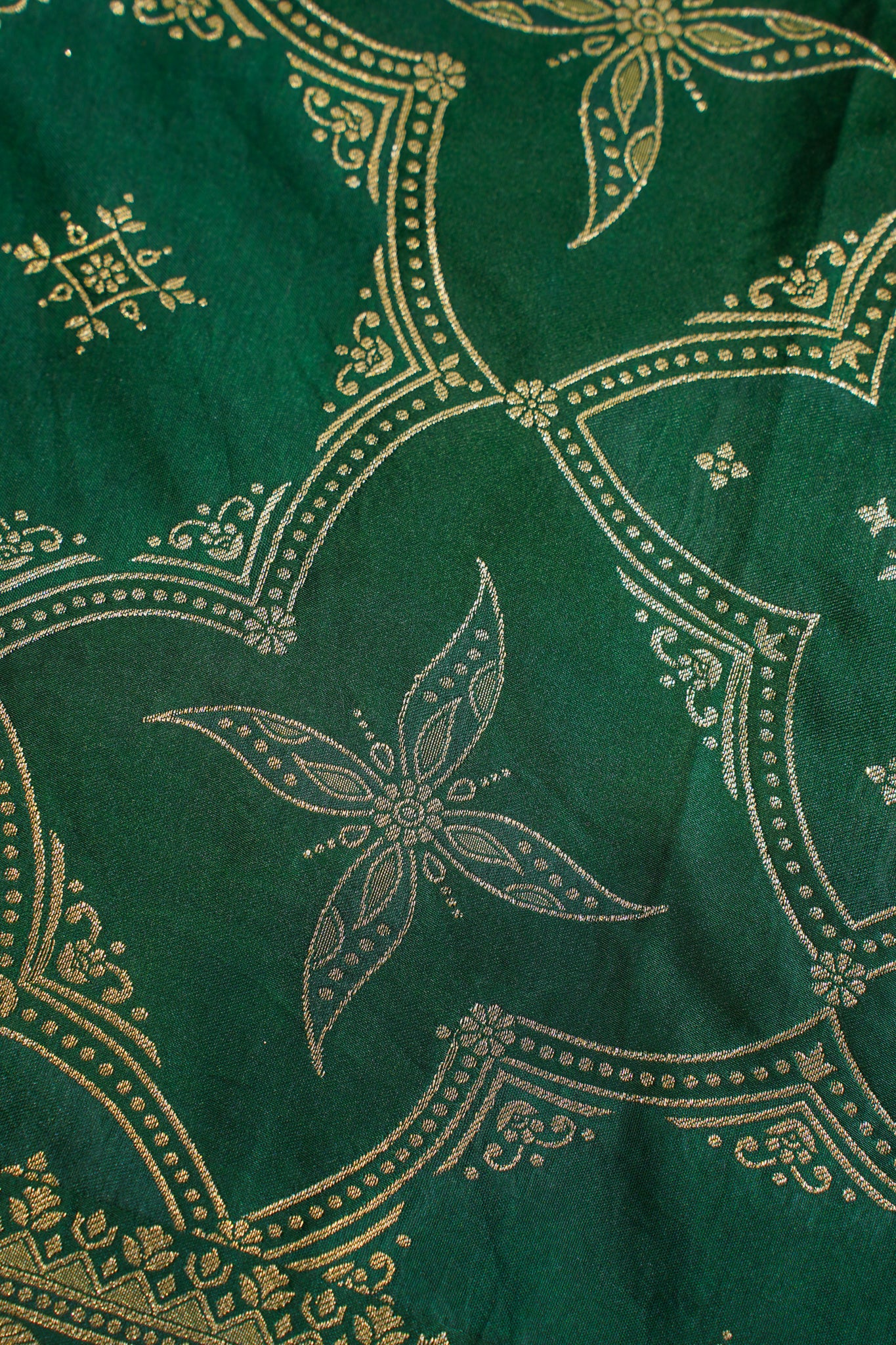 Close-up of green fabric with gold embroidery