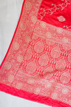 Red fabric with intricate gold patterns on a white background