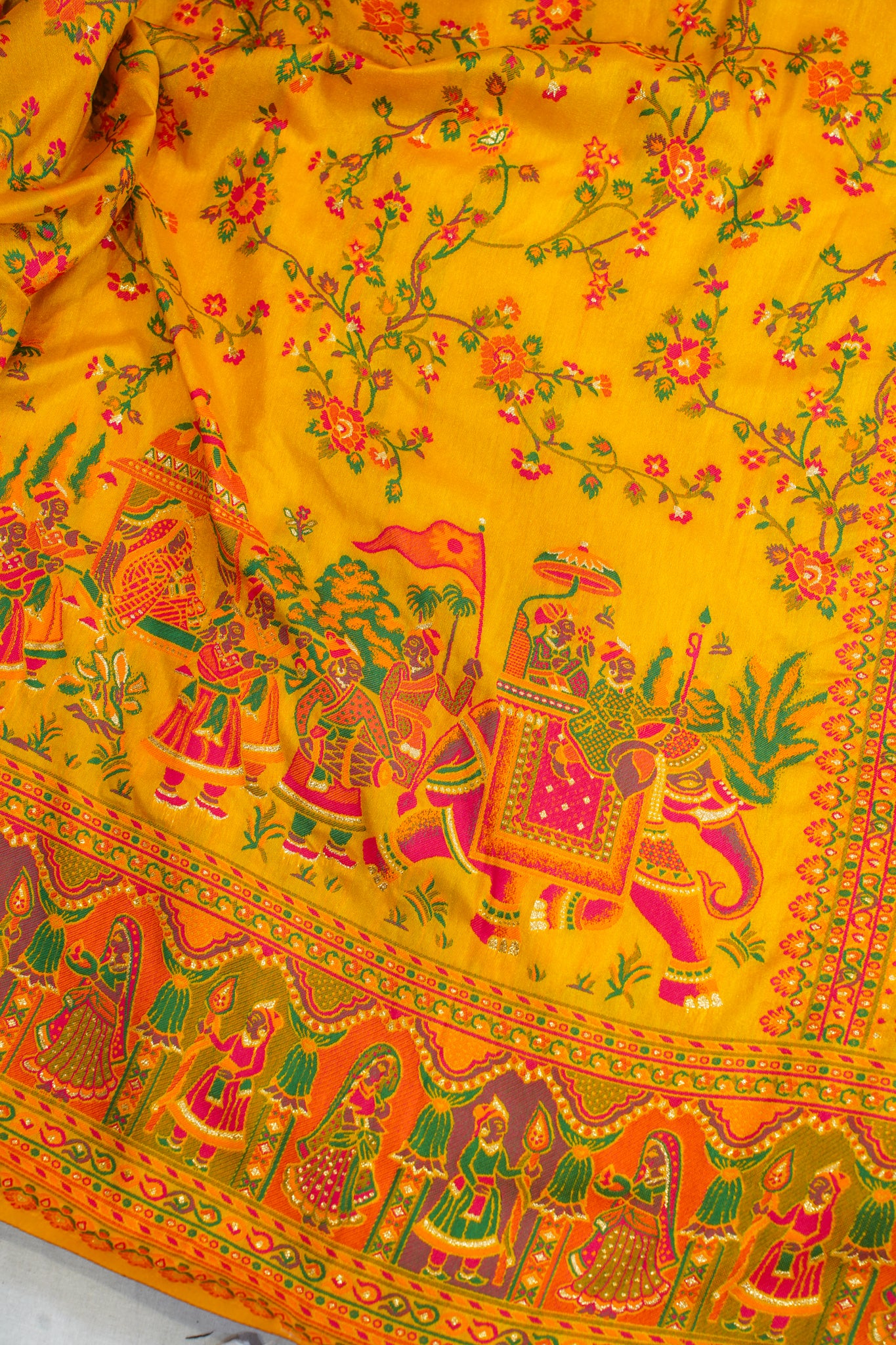 Traditional fabric with colorful patterns and characters on a yellow background
