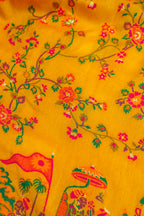 Yellow fabric with floral and elephant designs on a yellow background