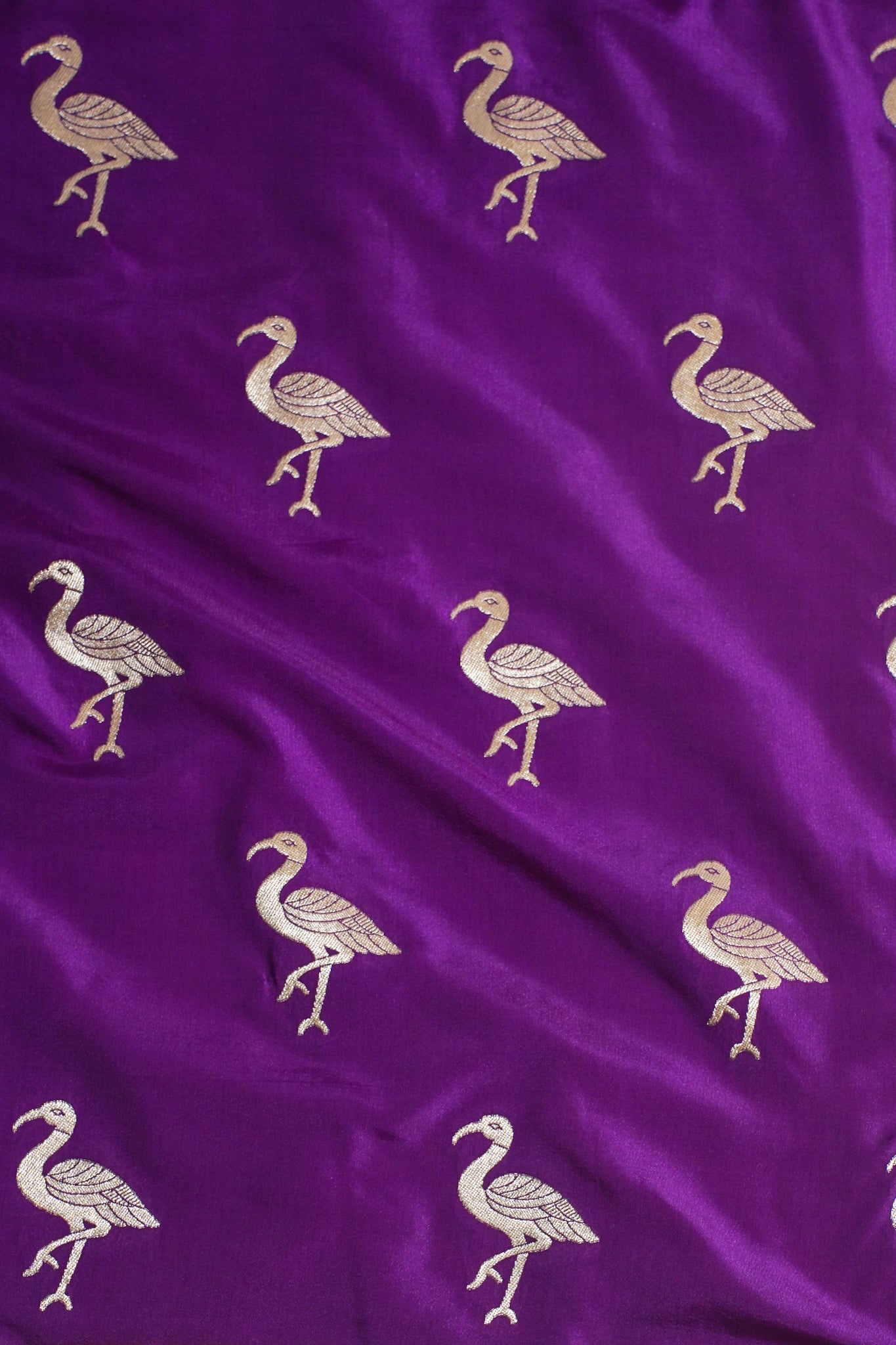 Purple fabric with gold flamingo patterns
