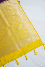 Yellow fabric with intricate patterns and tassels on a white background