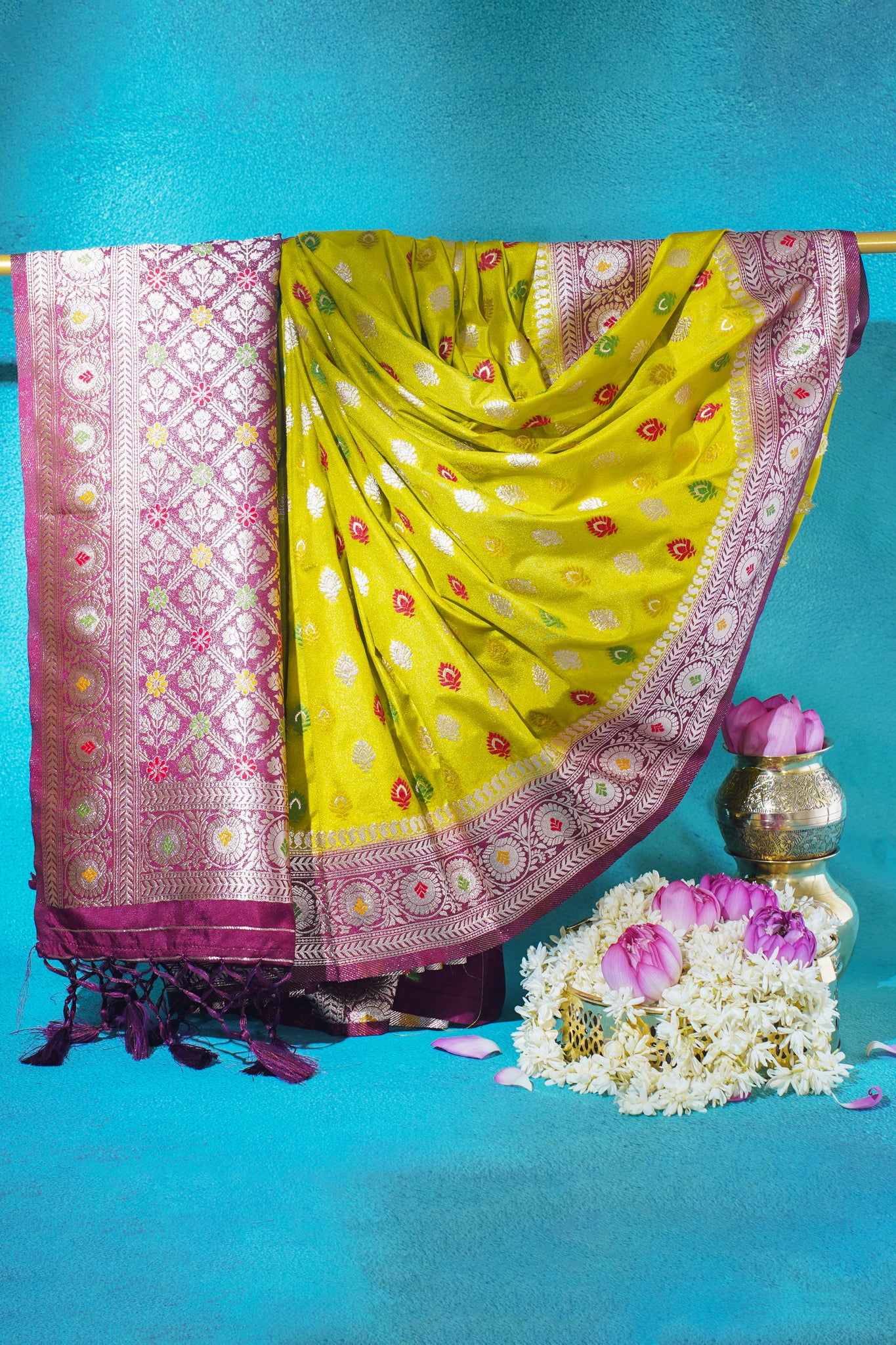 Yellow saree with pink border on a blue background