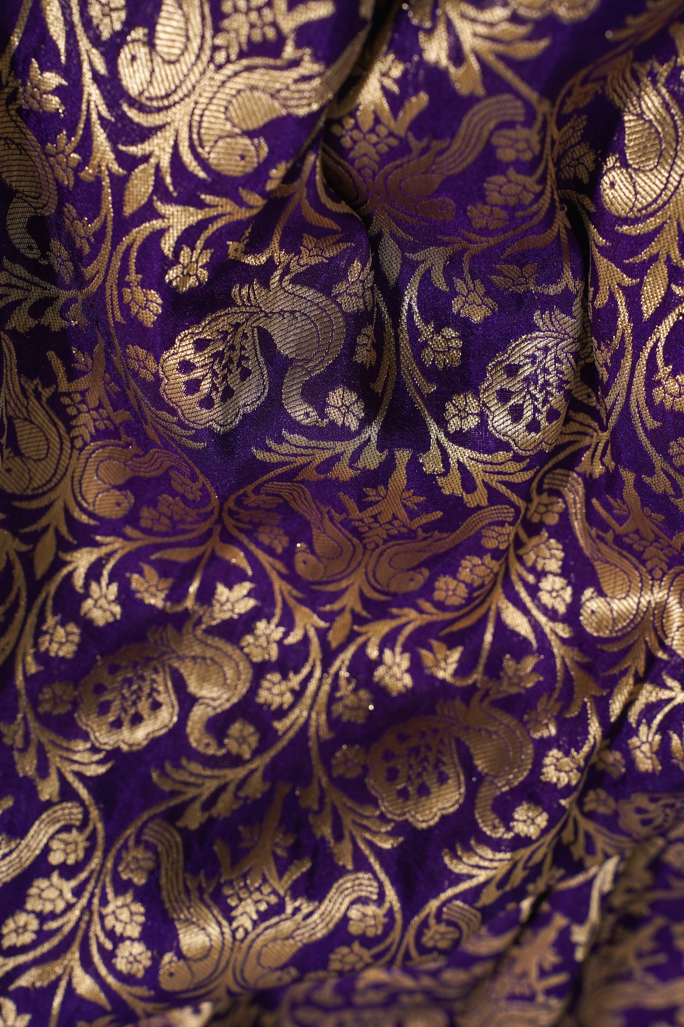 Close-up of purple fabric with gold floral patterns