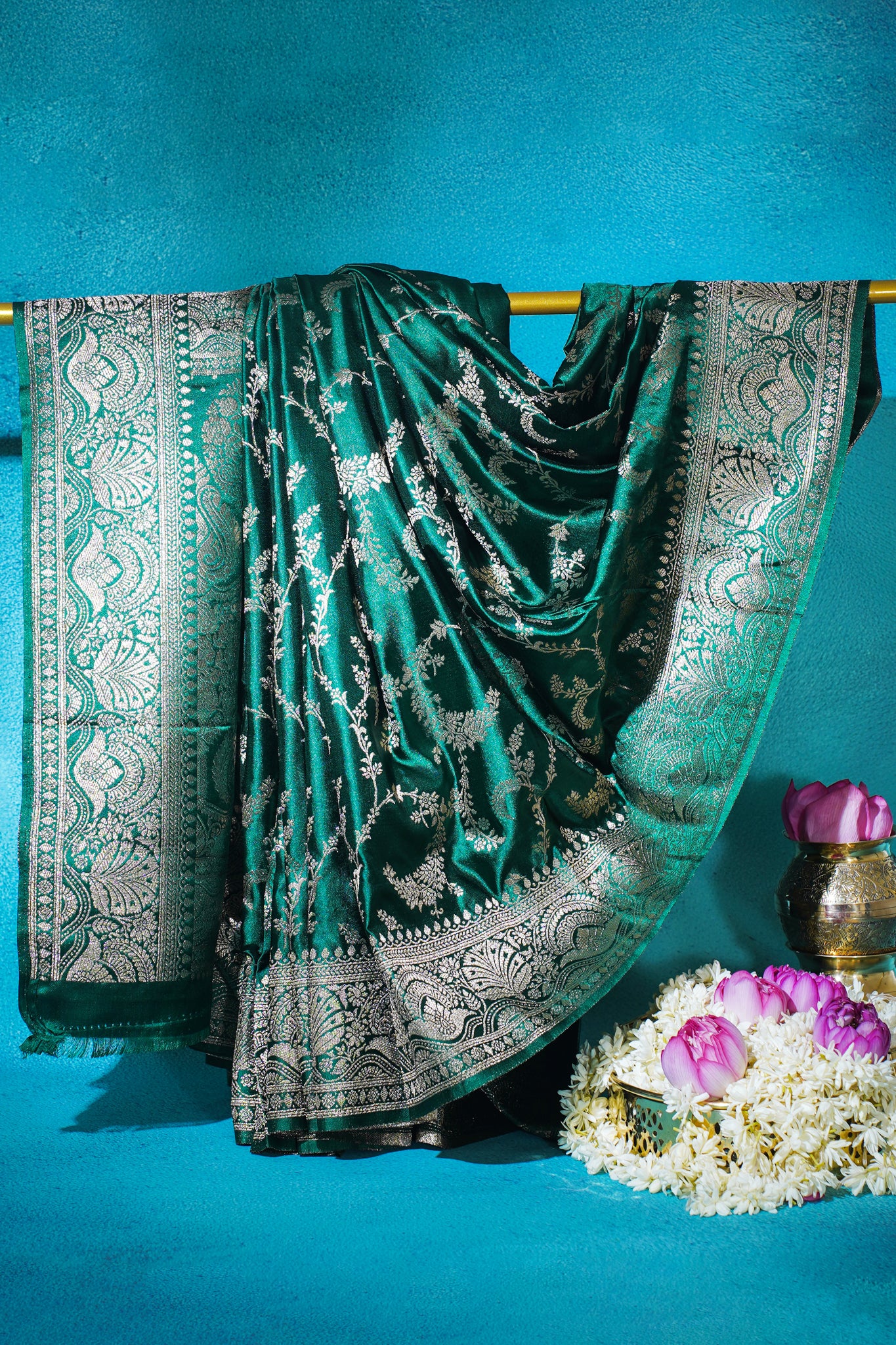 Green saree with silver patterns on a blue background