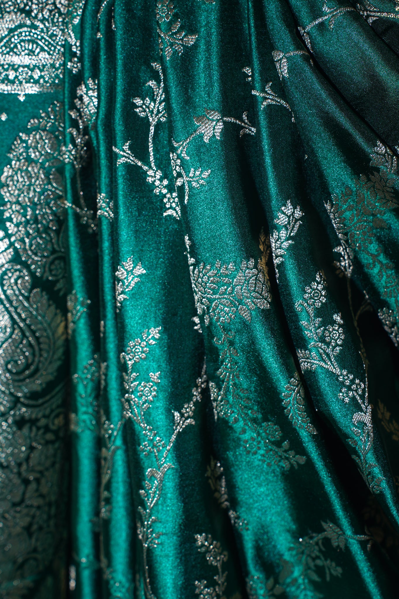 Close-up of green fabric with silver floral embroidery
