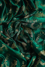 Close-up of green fabric with gold floral patterns
