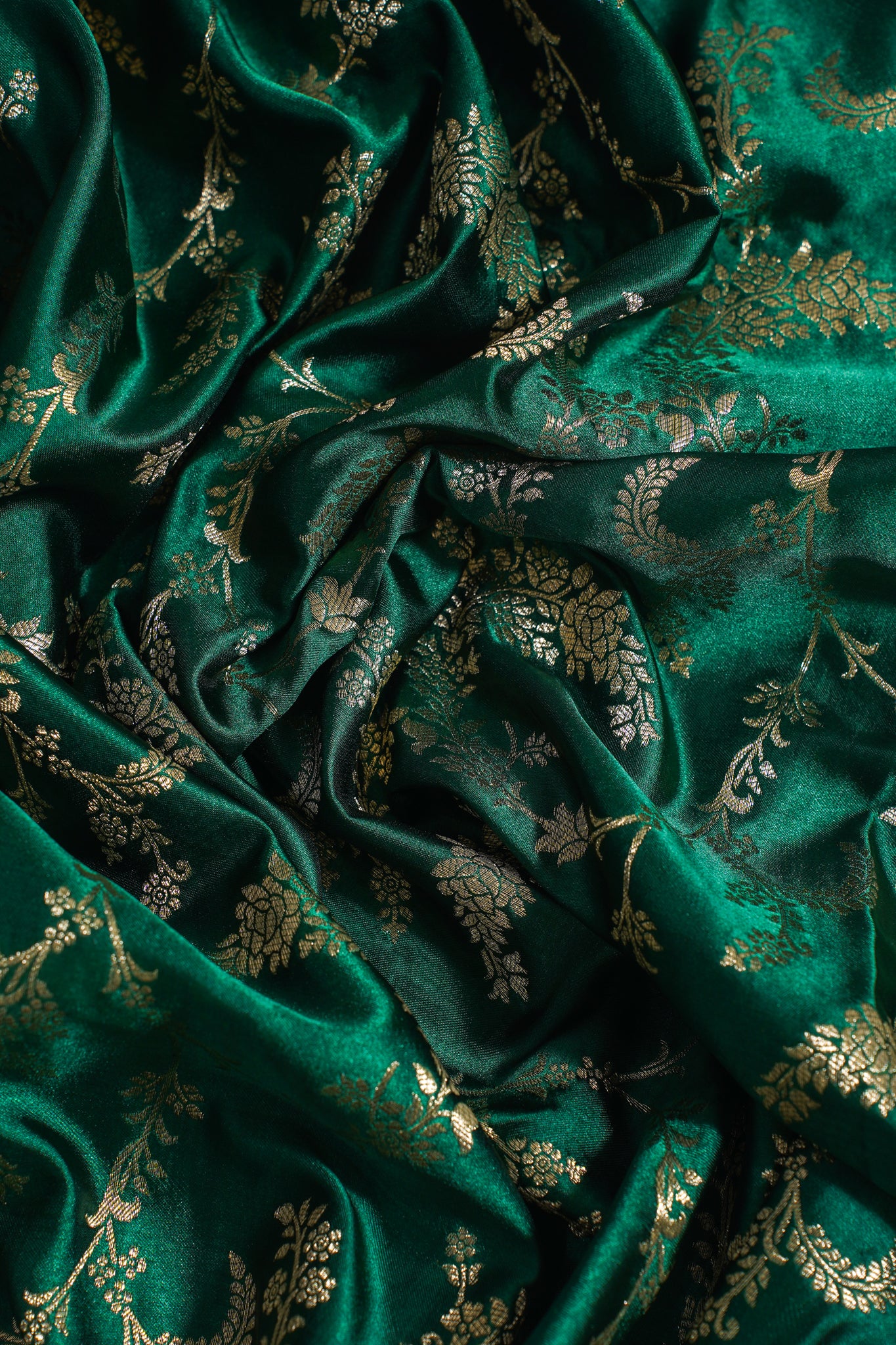 Close-up of green fabric with gold floral patterns
