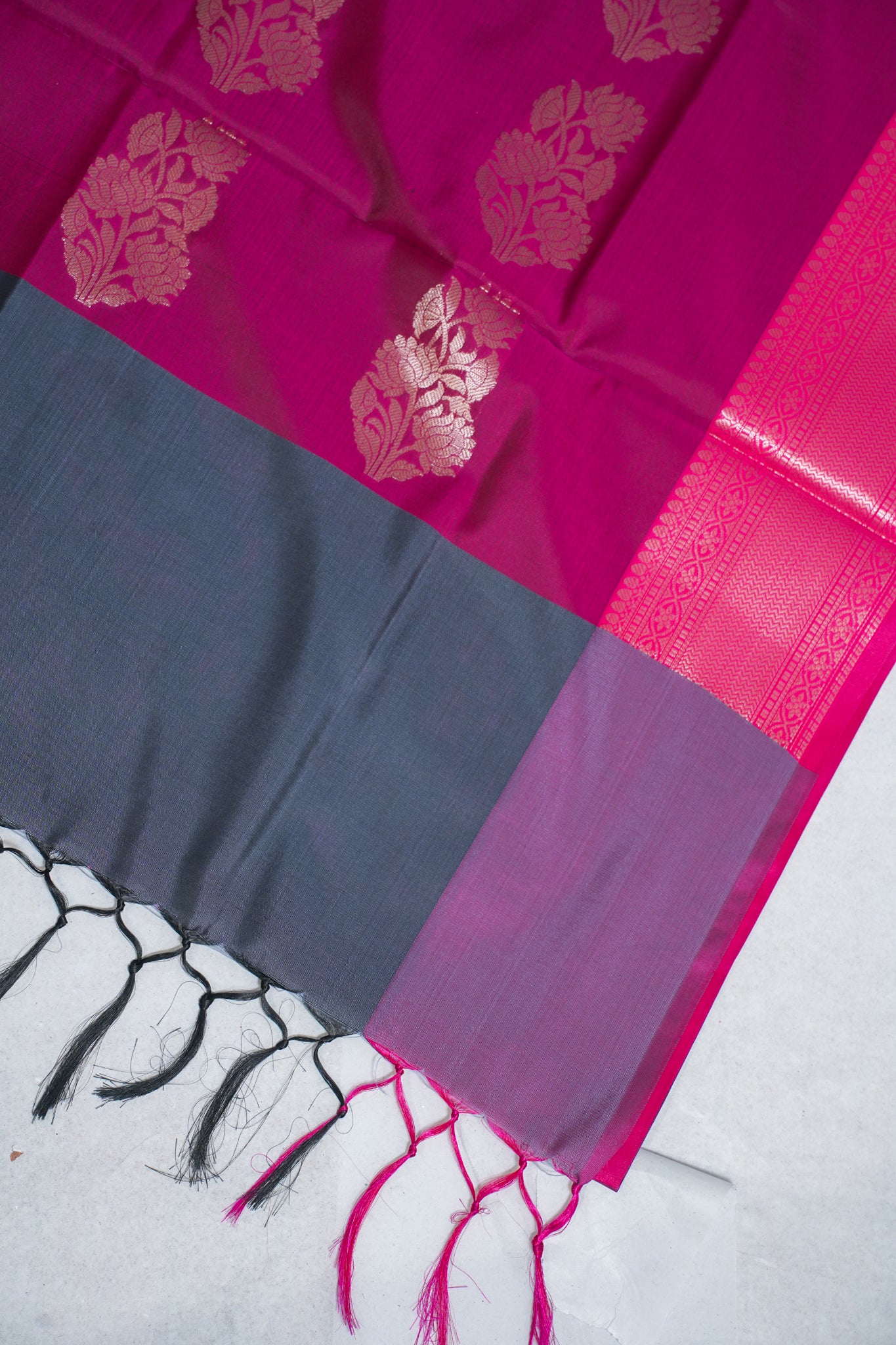 Pink saree with floral patterns and a gray border on a white background