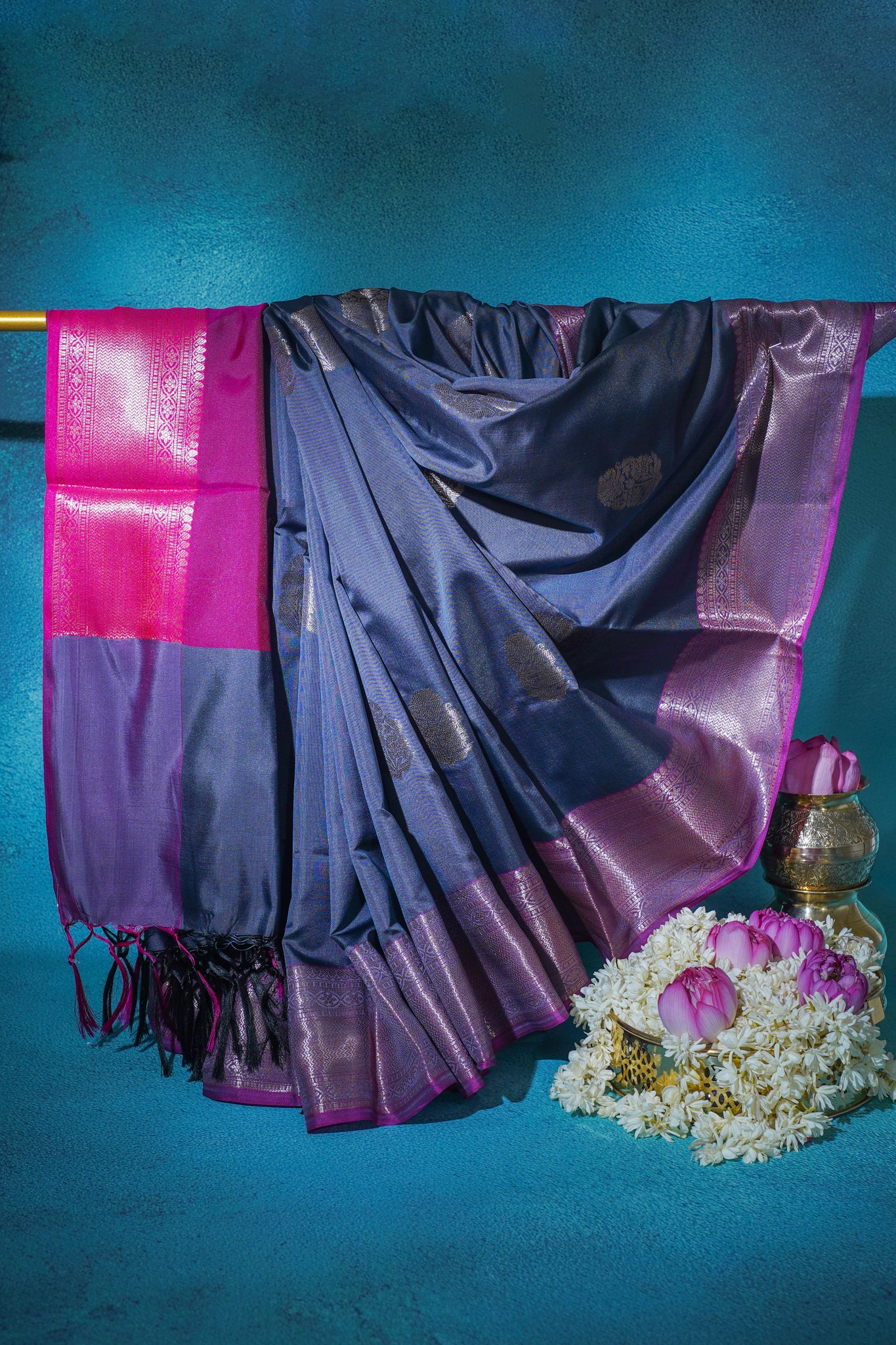 Purple and pink saree with floral decorations on a blue background