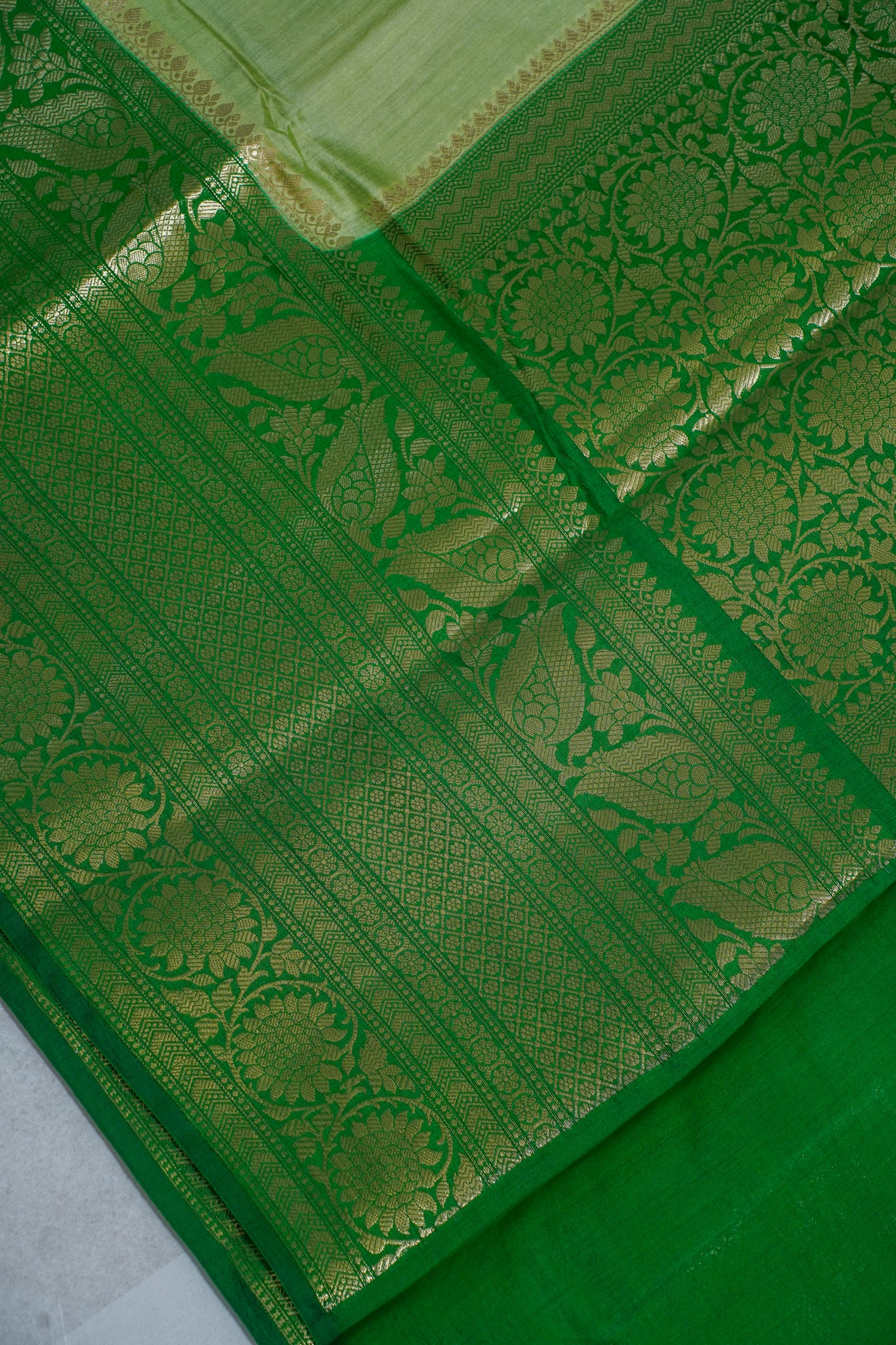 Green fabric with gold patterns on a white background