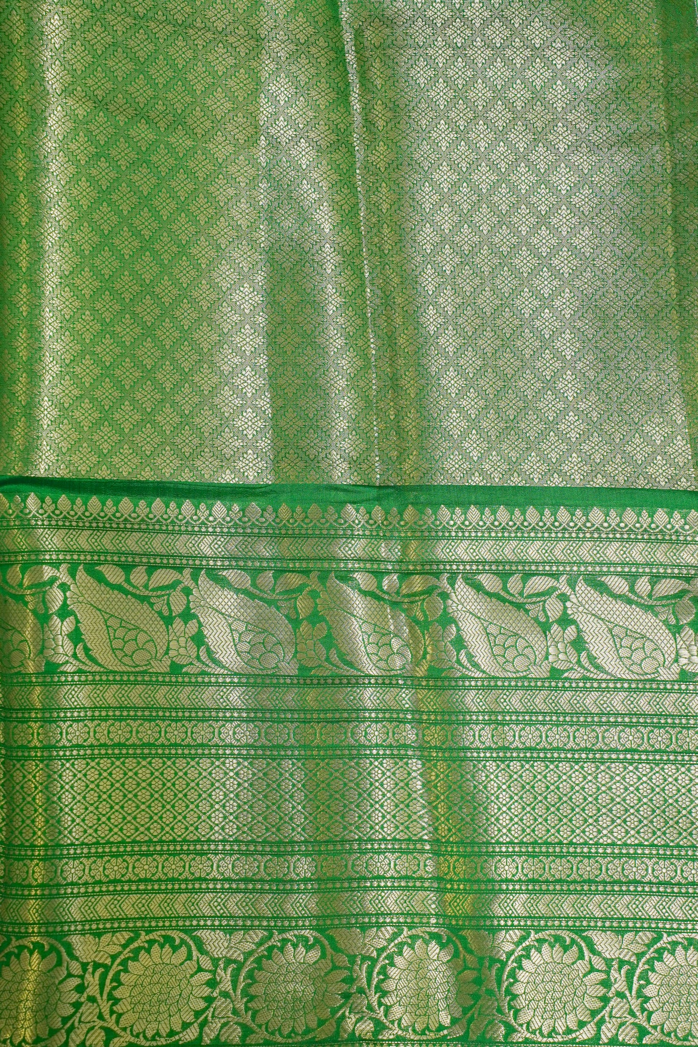 Green fabric with intricate patterns and borders