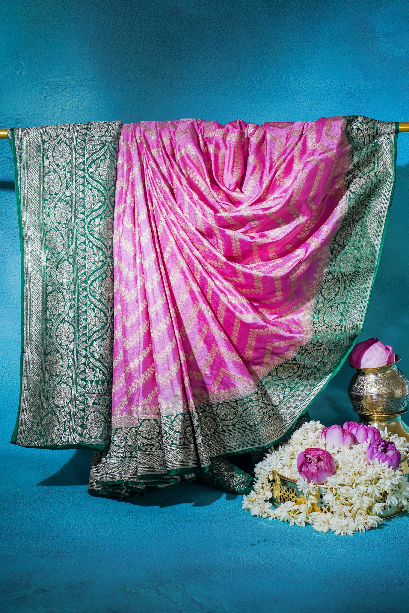 Pink and green saree with floral decorations on a blue background