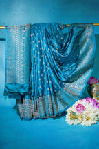 Blue saree with silver patterns on a blue background