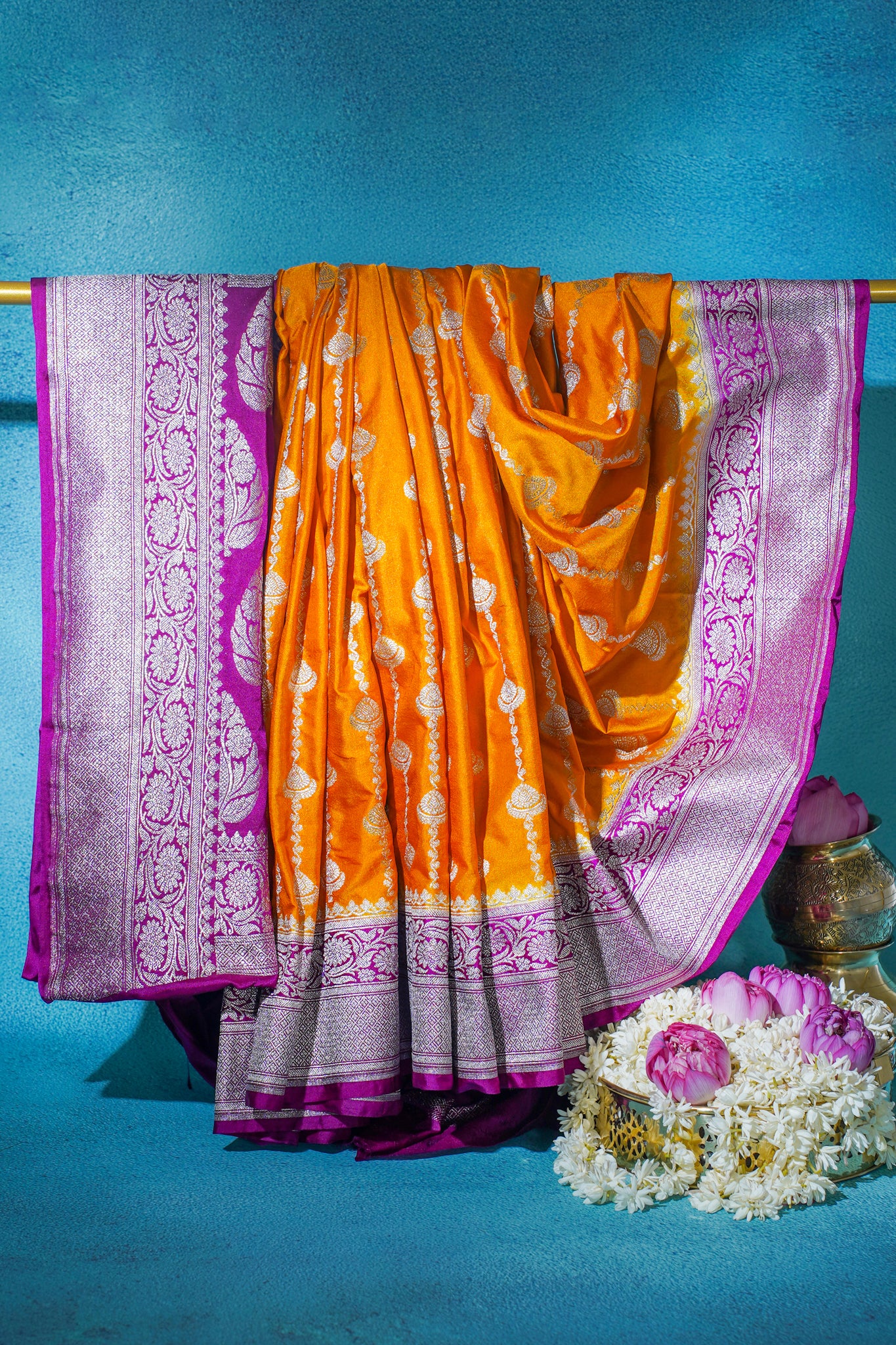 Orange saree with purple border on a blue background