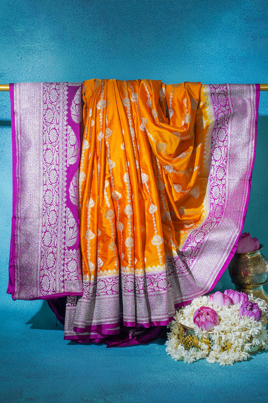 Orange saree with purple border on a blue background