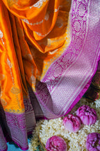 Orange saree with purple border on a floral background