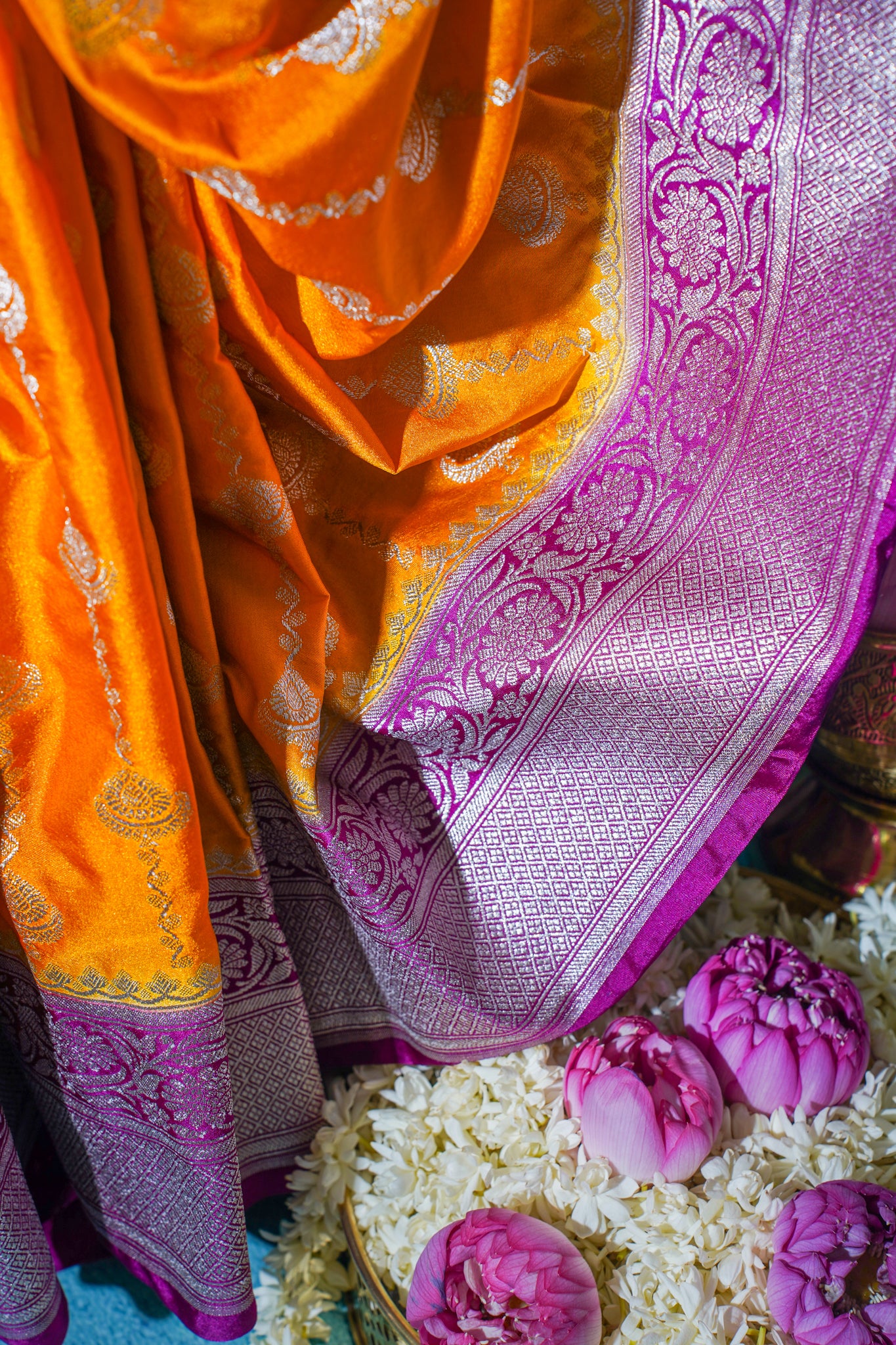 Orange saree with purple border on a floral background