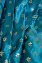 Close-up of blue fabric with gold floral patterns