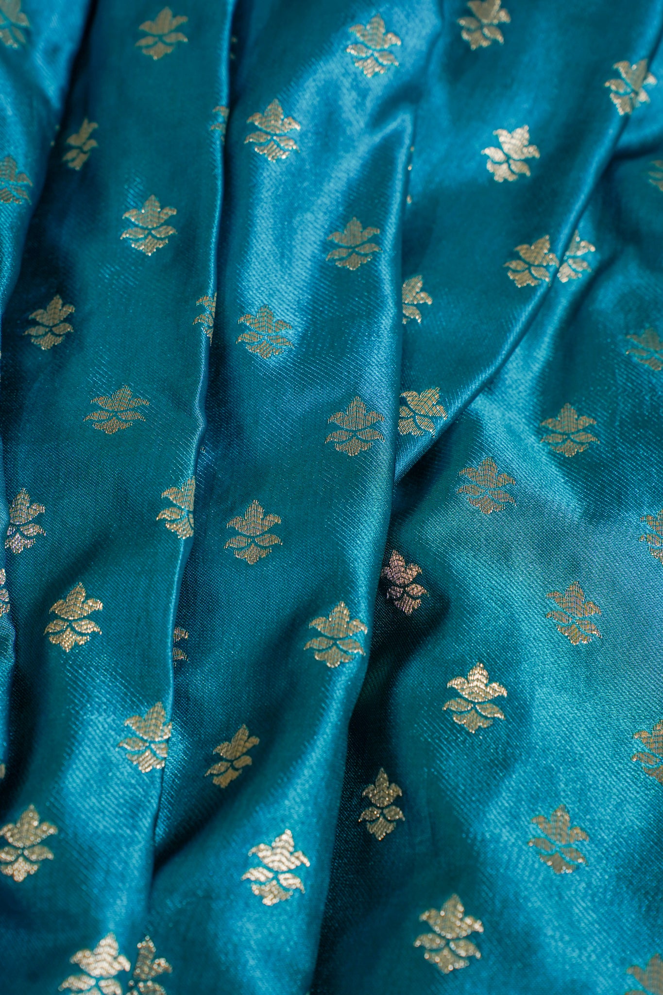 Close-up of blue fabric with gold floral patterns