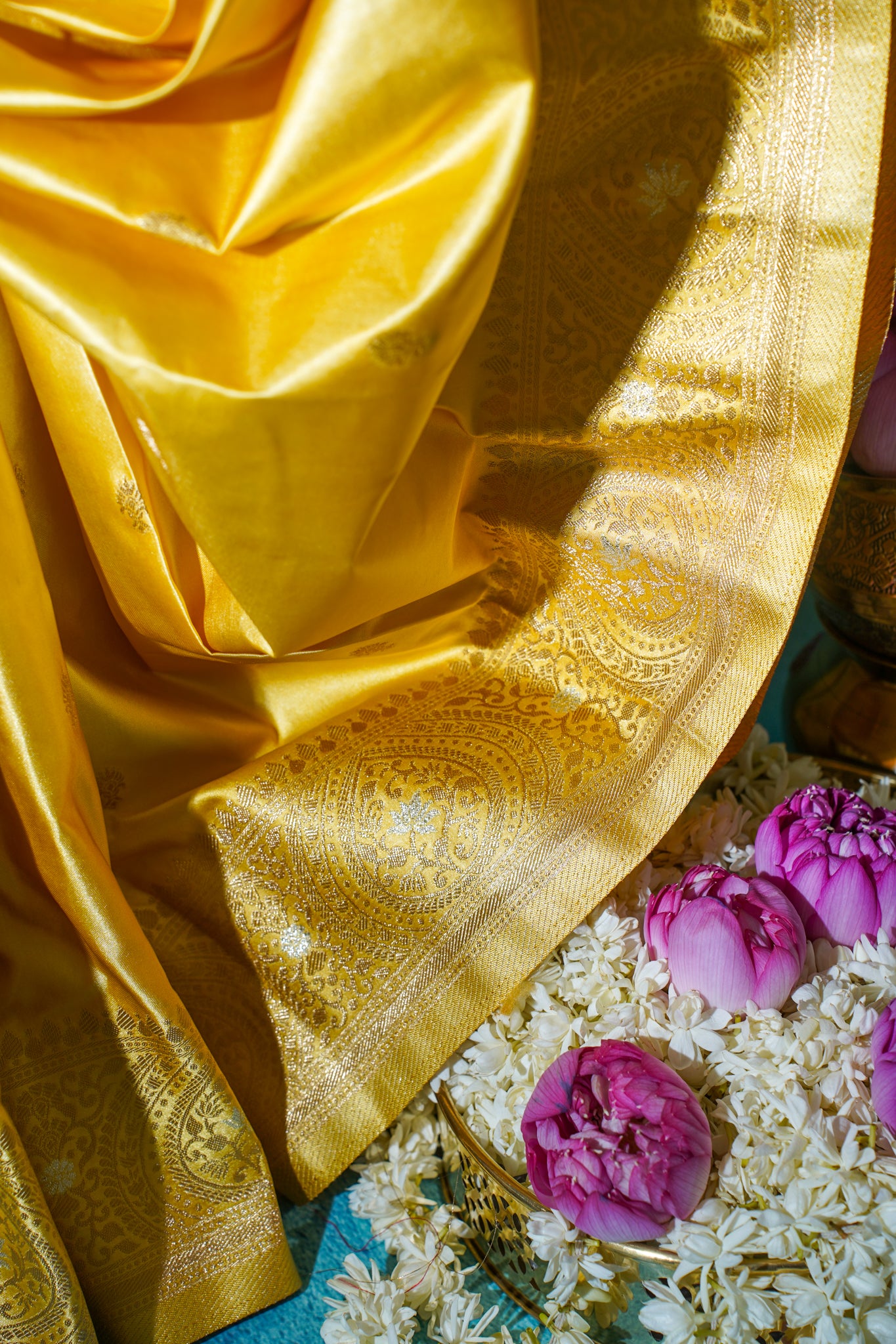 Gold saree with floral decorations on a textured surface