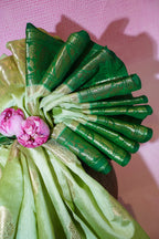Decorative green and gold fabric with pink flowers on a pink background
