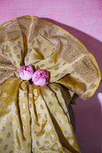 Gold fabric with pink flowers on a pink textured background