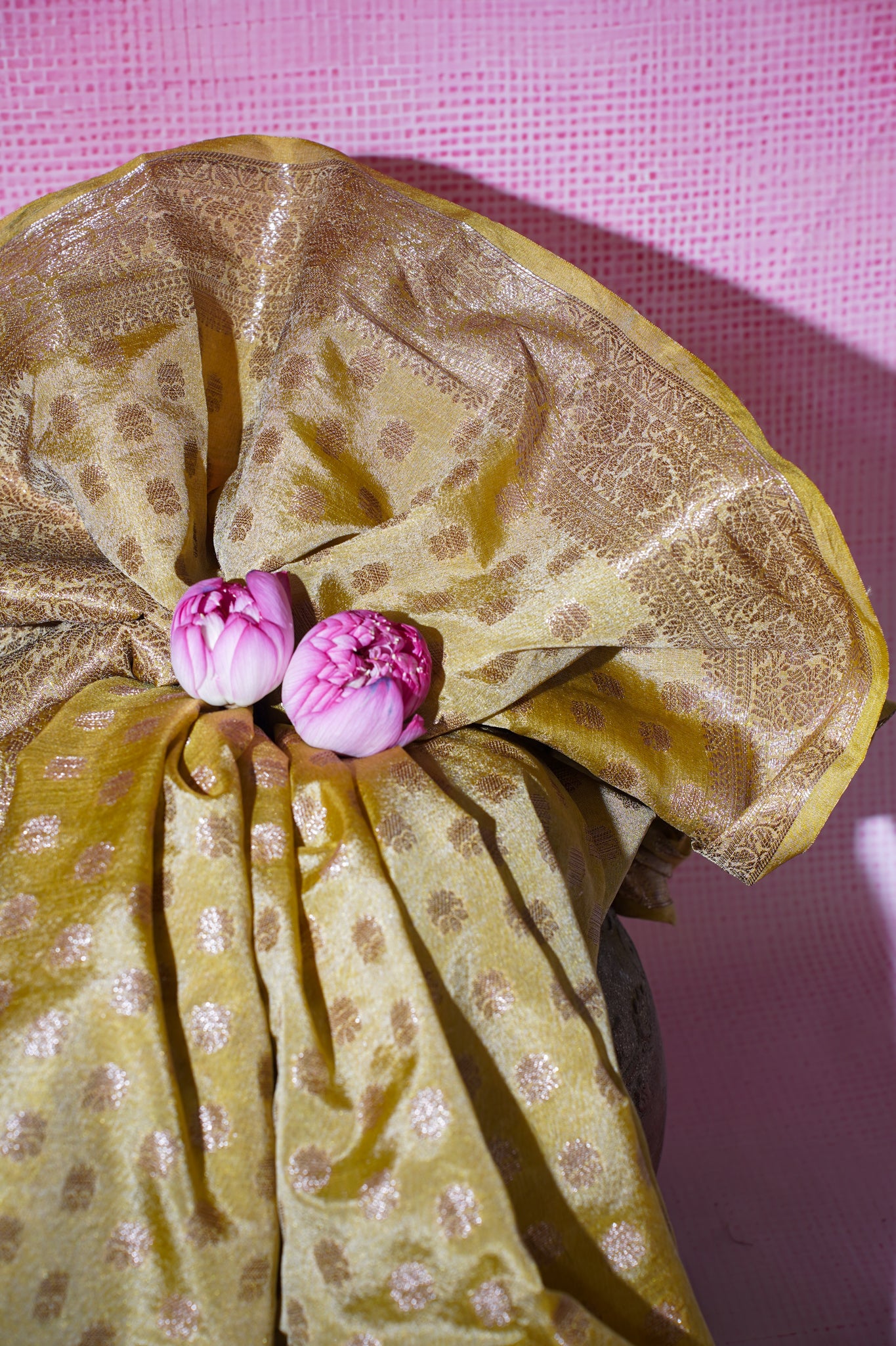 Gold fabric with pink flowers on a pink textured background