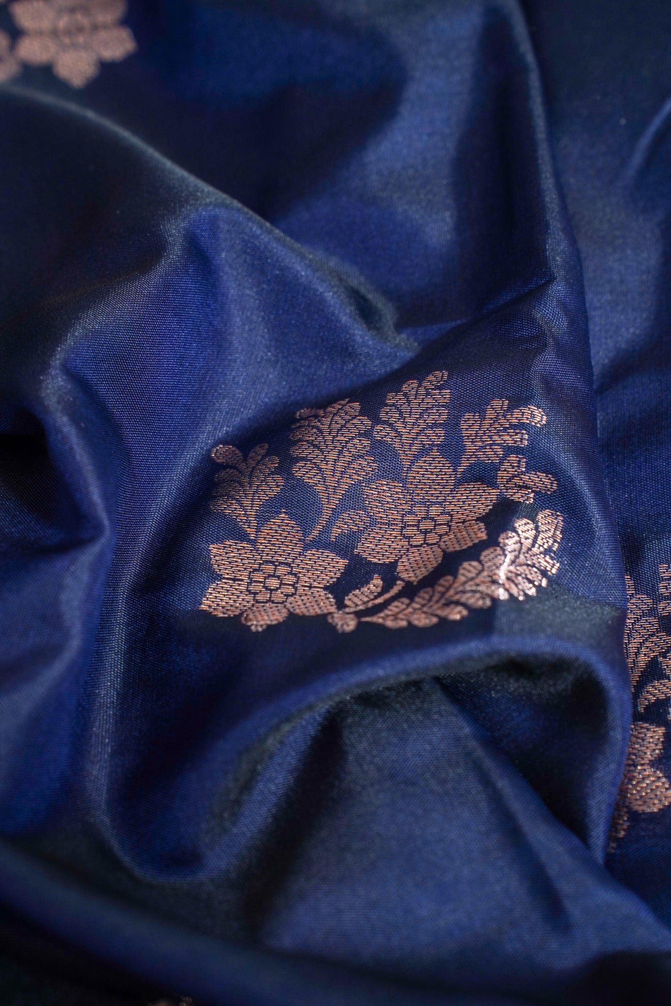Close-up of blue fabric with gold floral embroidery