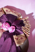 Decorative purple fabric with floral embellishments and gold embroidery on a pink background