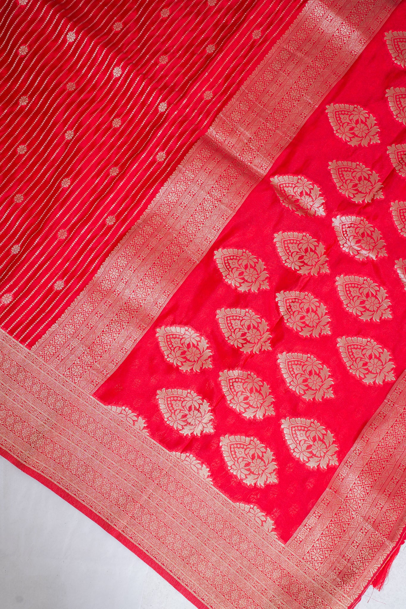 Red fabric with white floral patterns on a white background