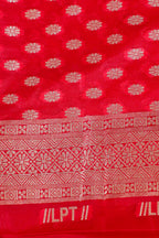 Red fabric with white floral patterns and text, possibly a textile sample.