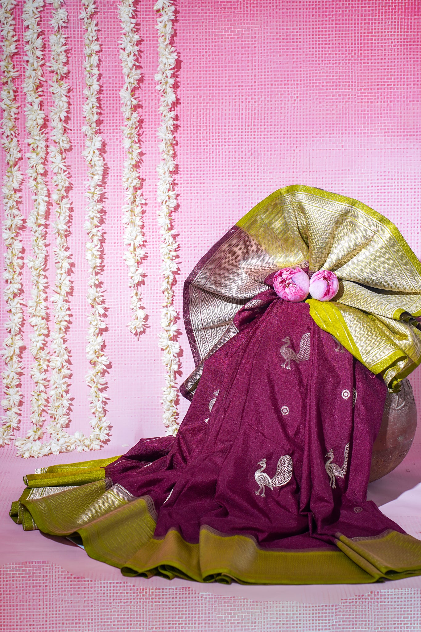 Decorative Purple saree with gold border with pink and green colors on a pink background